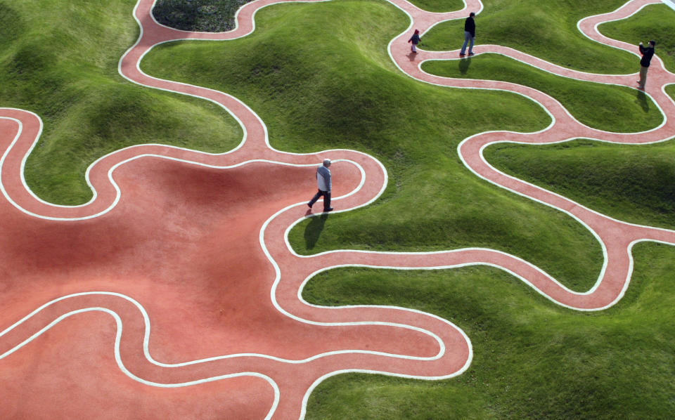 FILE - Visitors walk through a garden installation designed like the bottom-side of a leaf, on the opening day of the National Garden Festival "BUGA 05" in Munich, southern Germany, on April 28, 2005. The world is a stressful, sometimes lonely place. “It wasn’t supposed to be this way” is a phrase you hear a lot these days. But what if things could turn out another way? What if, somewhere, they had? Enter the realm of the multiverse and alternate realities, popular culture’s wildly glorified canvas — and a repository for the ache and longing of living in an uncertain era. (AP Photo/Uwe Lein, File)