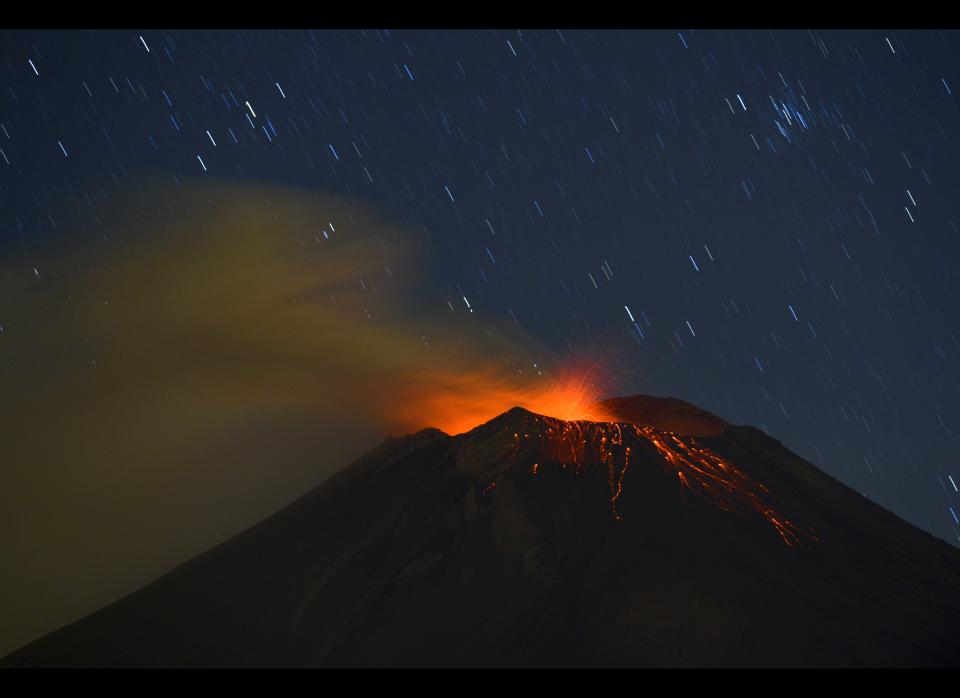 Incandescent materials, ash and smoke are spewed from the Popocatepetl Volcano as seen from Santiago Xalitzintla, in the Mexican central state of Puebla, on April 24, 2012. Residents at the foot of Mexico's Popocatepetl volcano no longer sleep soundly since the towering mountain roared back into action over a week ago, spewing out a hail of rocks, steam and ashes. The volcano, Mexico's second highest peak at 5,452 metres, started rumbling and spurting high clouds of ash and steam on April 13, provoking the authorities to raise the alert to level five on a seven-point scale. AFP PHOTO//RONALDO SCHEMIDT        (Photo credit should read Ronaldo Schemidt/AFP/GettyImages)