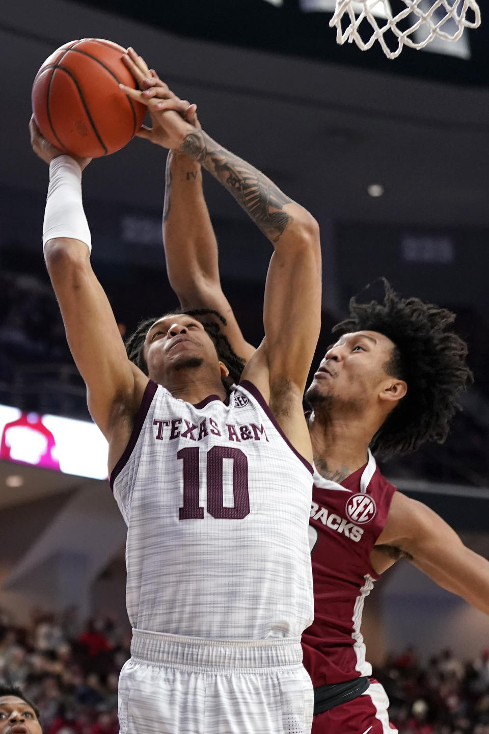 Texas A&M forward Ethan Henderson (10) shoots a basket as Arkansas forward Jaylin Williams (10) defends during the second half of an NCAA college basketball game Saturday, Jan. 8, 2022, in College Station, Texas. (AP Photo/Sam Craft)