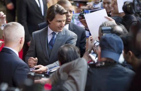 U.S. actor Tom Cruise signs autographs at a British screening of the film "Mission Impossible: Rogue Nation" in London, Britain July 25, 2015. REUTERS/Neil Hall/Files