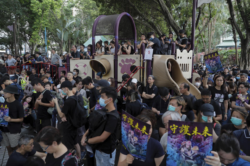 People gather at a playground of Belcher Bay Park as they take part in an anti-extradition bill protest in Hong Kong, Sunday, Aug. 4, 2019. Protesters held two more rallies Sunday after Hong Kong police announced more than 20 people were arrested following clashes at an earlier demonstration, adding to increasingly tense confrontations with the Chinese territory's government. The sings read "Protect the future." (AP Photo/Kin Cheung)