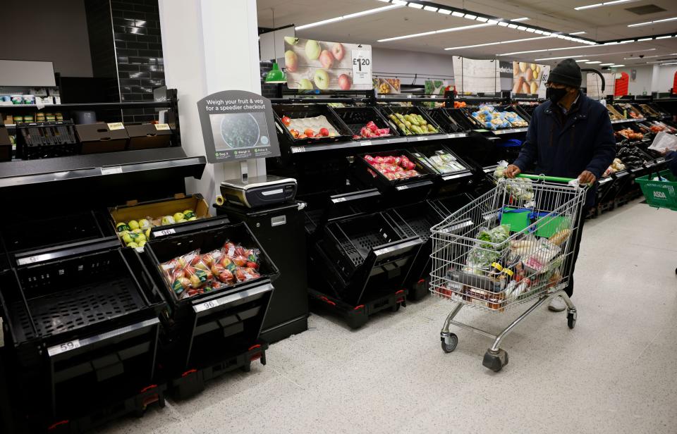 A shopper wearing a face mask or covering due to the COVID-19 pandemic, pushes a trolley past empty fruit and vegetable troughs inside an ASDA supermarket in Walthamstow in north east London on December 22, 2020. - The British government said Tuesday it was considering tests for truckers as part of talks with French authorities to allow the resumption of freight traffic suspended due to a new strain of coronavirus. Britain was plunged into fresh crisis last week with the emergence of a fresh strain of the virus, which is believed to be up to 70 percent more transmissible than other forms. (Photo by Tolga Akmen / AFP) (Photo by TOLGA AKMEN/AFP via Getty Images)