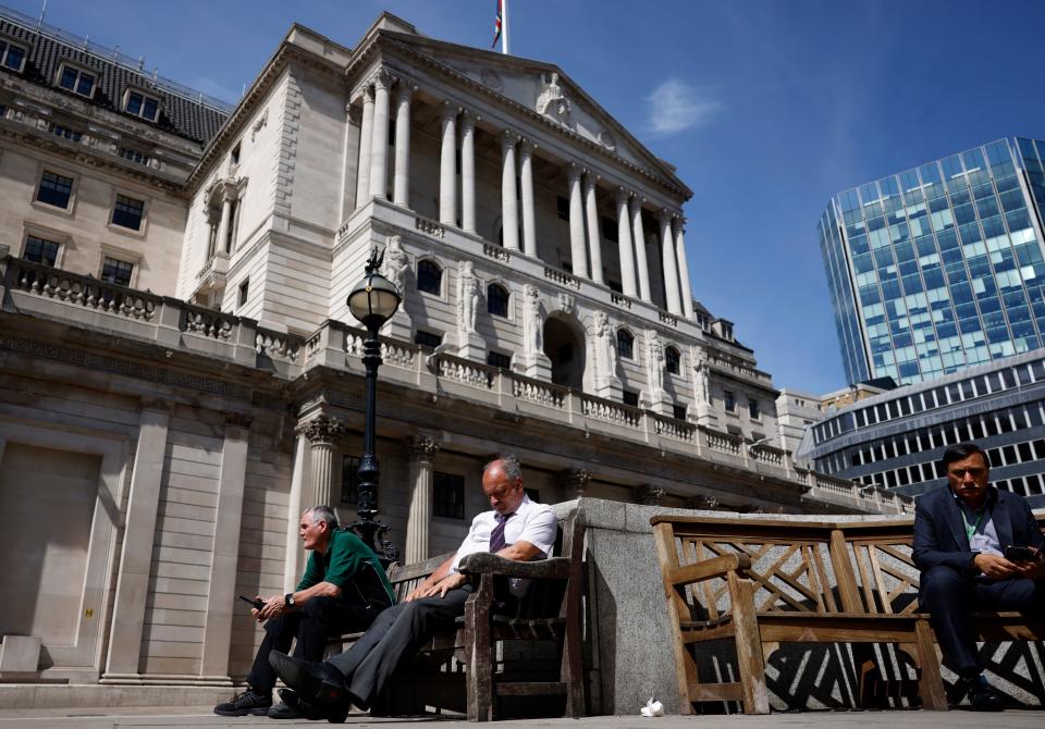 Members of the public take a break in the sunshine outside The Bank of England in London on June 16, 2022. - The Bank of England on Thursday hiked its main interest rate for a fifth straight time, as it forecast British inflation to soar further this year to above 11 percent. (Photo by CARLOS JASSO / AFP) (Photo by CARLOS JASSO/AFP via Getty Images)