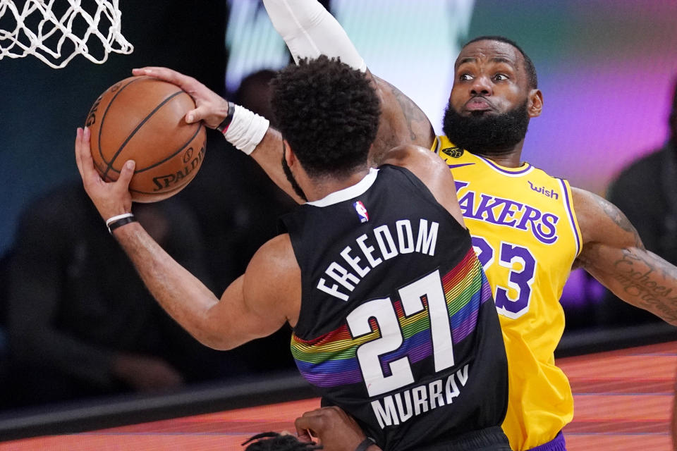 Denver Nuggets' Jamal Murray (27) drives against Los Angeles Lakers' LeBron James (23) and scores during the first half of an NBA conference final playoff basketball game Thursday, Sept. 24, 2020, in Lake Buena Vista, Fla. (AP Photo/Mark J. Terrill)