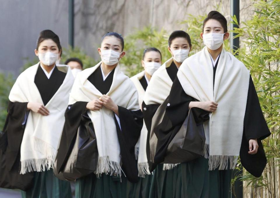 Takarazuka Music School students wear masks as they head to their graduation ceremony in Takarazuka, western Japan, on 2 March, amid the spread of the coronavirus.