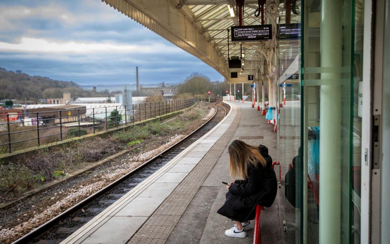 Person waiting for a train - Aslef claims four train companies backed down on using minimum service levels