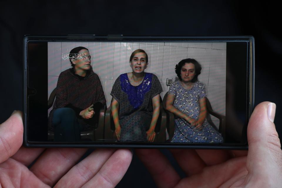 ISRAEL - OCTOBER 30: In this photo illustration, a phone displays footage released by Hamas today showing three hostages, purportedly held in captivity in Gaza, on October 30, 2023. Hamas has demanded a prisoner exchanger for some of the hostages it has held since its Oct 7 attacks, which left 1,400 dead and 230 kidnapped, according to Israeli officials. The fate of those hostages has complicated the country's military response. Families of the victims worry that the military offensive may result in hostages being killed during Israeli bombing or from Hamas's reprisals. Some families and friends of hostages, who remain in Gaza, are calling on the government to trade for Palestinian prisoners. (Photo by Dan Kitwood/Getty Images) ORG XMIT: 776055761 ORIG FILE ID: 1753504910