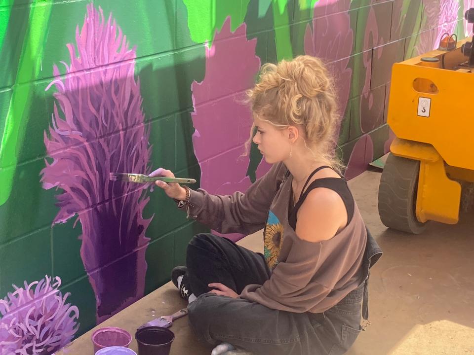 Rebecca Canum, a senior at Lanphier High School, applies touches to a prairie blazing star on the "Local Heroes" mural at the new Springfield-Sangamon County Transportation Hub on the 10th Street corridor. In addition to Presidents Abraham Lincoln and Barack Obama and other important figures in Springfield and Illinois history, the 61-foot by 47-foot mural features flowers native to Illinois.