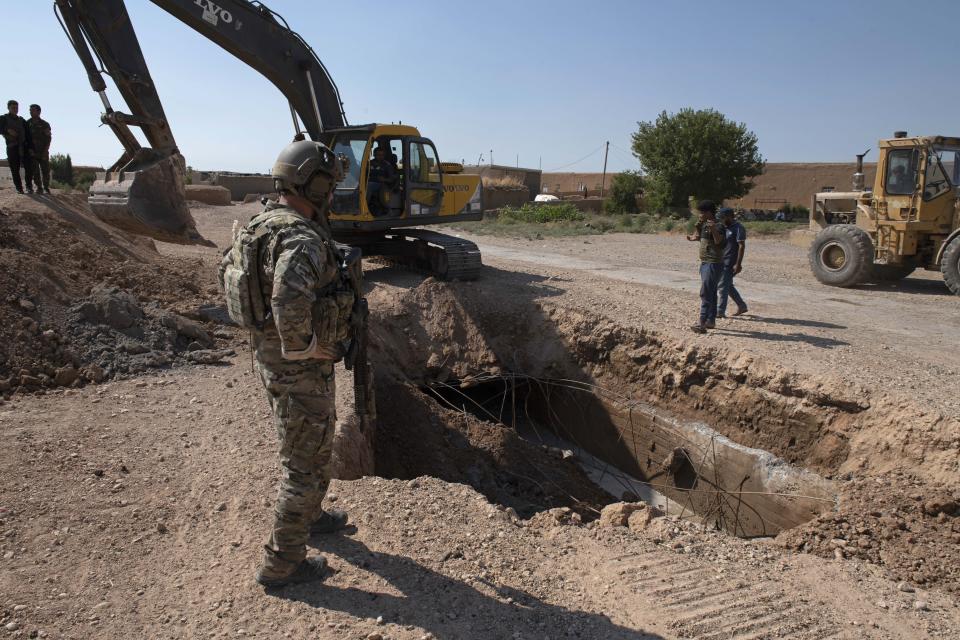 In this Aug. 22, 2019 photo, provided by the U.S. Army, shows A U.S. service member watches as Syrian Democratic Forces remove military fortifications during the implementation of the security mechanism along the Turkey-Syria border in northeast Syria. Ilham Ahmed, co-chair of the executive committee of the U.S-backed Syrian Democratic Council said Tuesday, Sept. 3, 2019, that the creation of a so-called “safe zone” in northeastern Syria is off to good start, with U.S.-backed Kurdish-led forces pulling back from an initial part of the border with Turkey, but calm can only prevail if Turkey also removes its troops. (Spc. Alec Dionne/U.S. Army via AP )