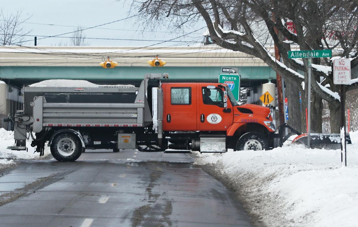 An Akron City snow plow crosses Archwood Avenue as it clears  Allendale Avenue in the East Akron neighborhood of Akron.