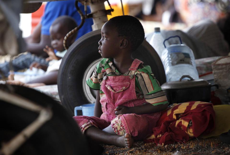 A child sits under an old airplane at Mpoko international airport in Bangui