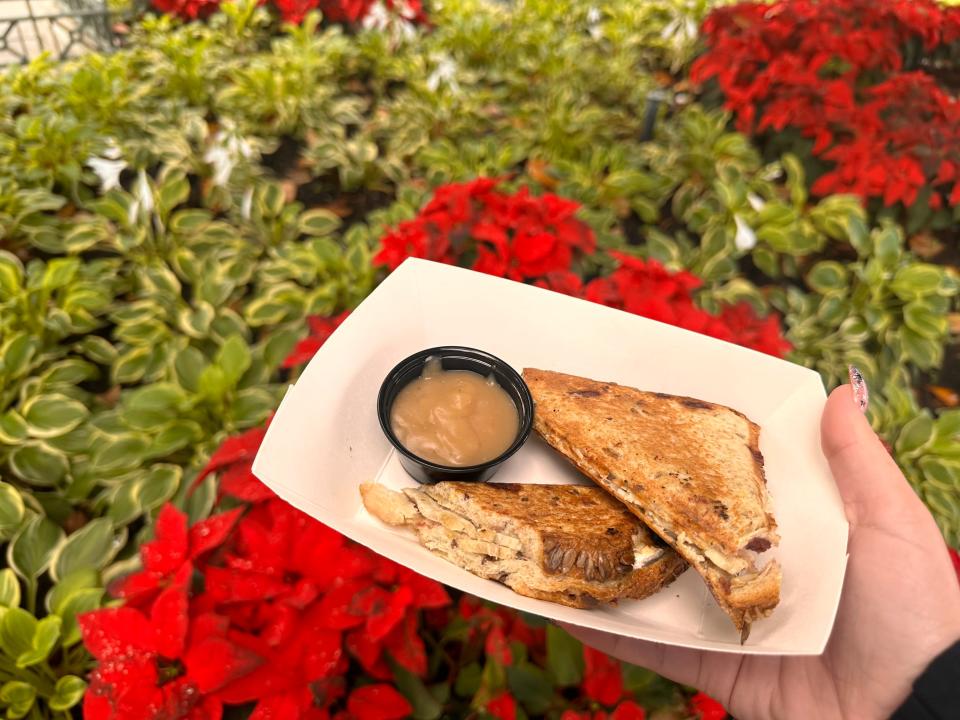 carly holding a container with a turkey sandwich and dipping sauce at universal