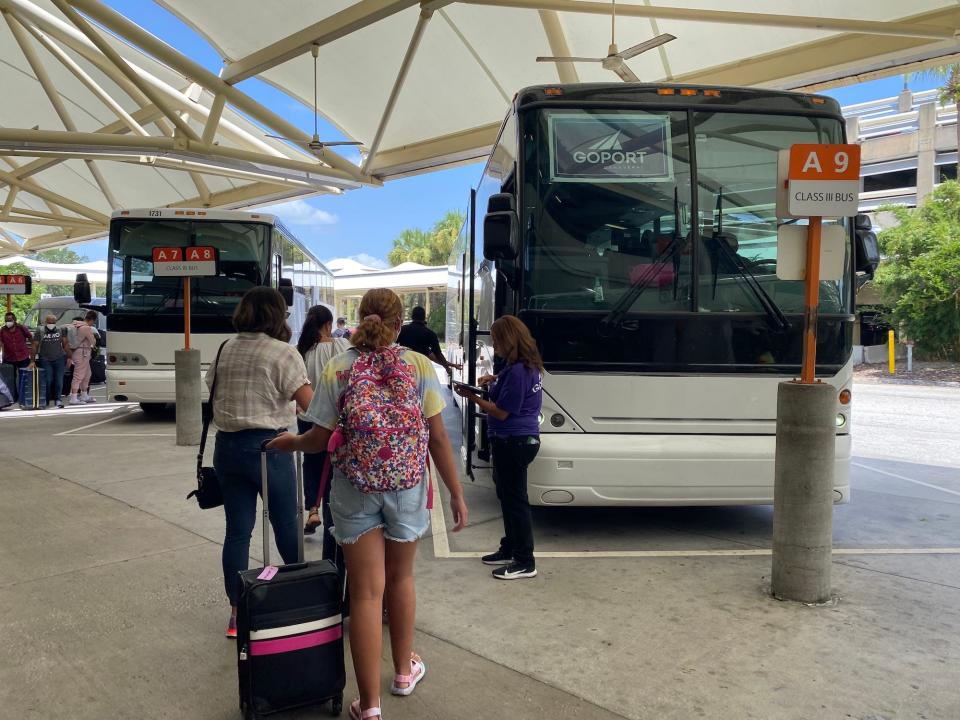 Travelers board a Go Port bus at the Orlando International Airport.