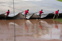 Grounds crew pulls the tarp to cover the baseball diamond from a heavy downpour delaying the baseball game during the sixth inning of a baseball game between the Washington Nationals and the Baltimore Orioles in Washington, Sunday, Aug. 9, 2020. (AP Photo/Manuel Balce Ceneta)