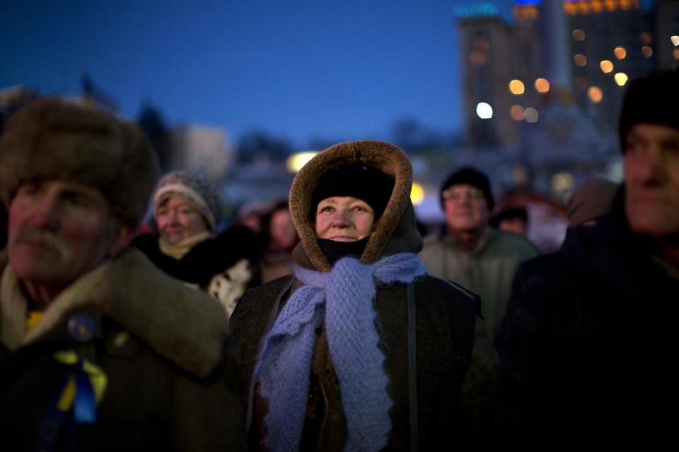 Men and women listen to a political speech inside Kiev's Independence Square, the epicenter of the country's current unrest, Ukraine, Friday, Jan. 31, 2014. Police on Friday opened an investigation into the kidnapping of an opposition activist, who said he was held captive for more than a week and tortured in the latest in a string of mysterious attacks on anti-government protesters in the two-month-long political crisis. (AP Photo/Emilio Morenatti)