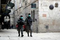 Israeli police wearing masks walk near a bronze sculpture by Italian artist Alessandro Mutto at one of the Stations of the Cross along the Via Dolorosa, amid the coronavirus disease (COVID-19) outbreak in Jerusalem's Old City