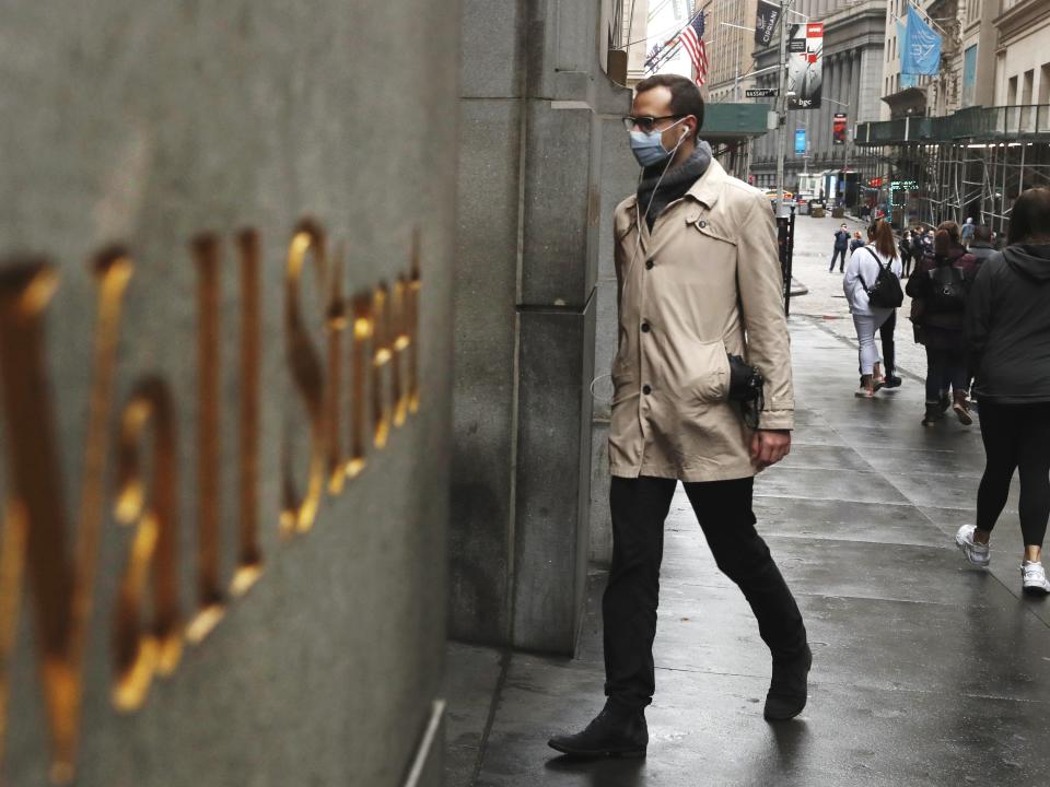 FILE PHOTO: A man wears a protective mask as he walks on Wall Street during the coronavirus outbreak in New York City, New York, U.S., March 13, 2020. REUTERS/Lucas Jackson