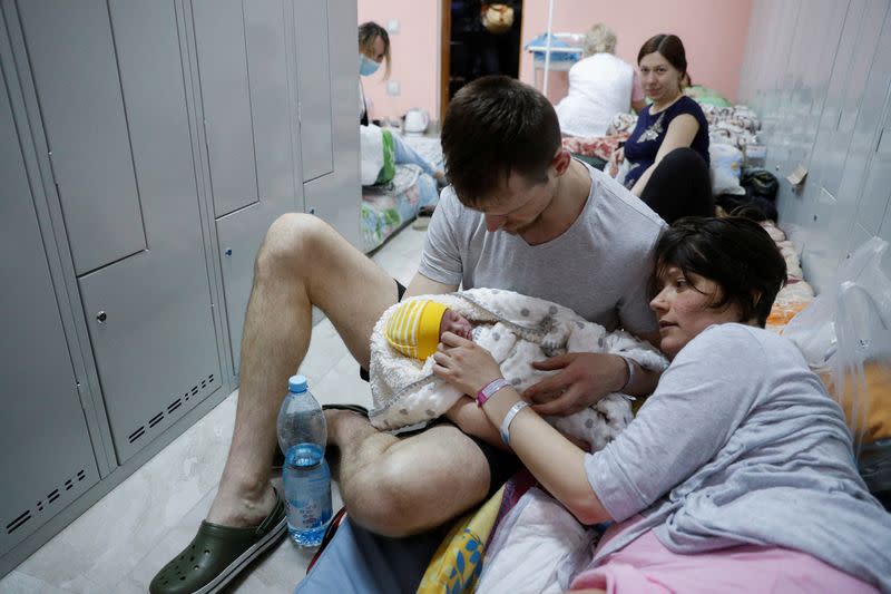 A couple with their newborn baby take shelter in the basement of a perinatal centre as air raid siren sounds are heard amid Russia's invasion of Ukraine, in Kyiv