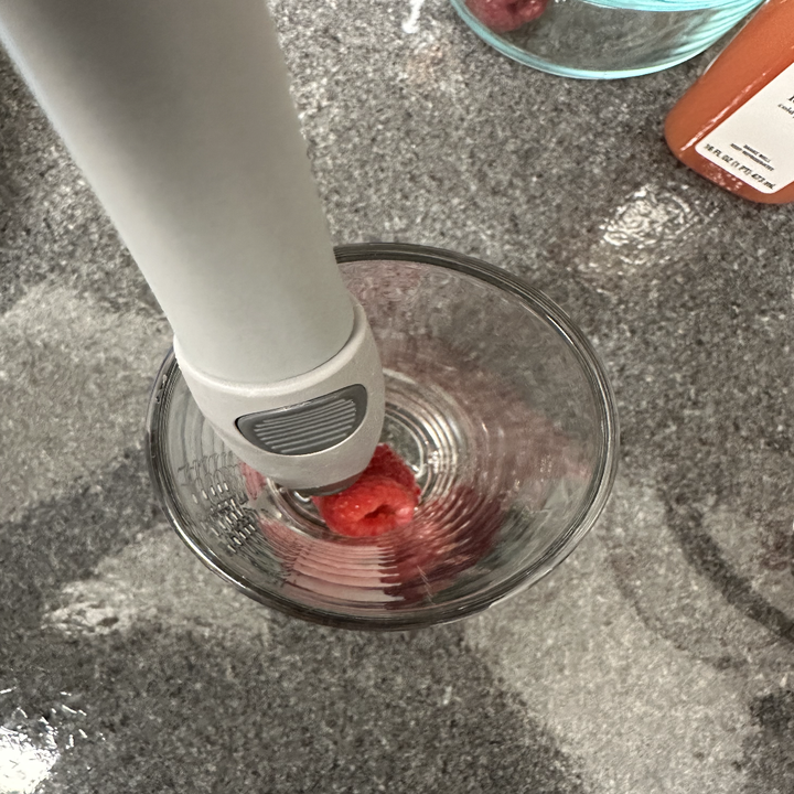 muddling raspberries in a glass