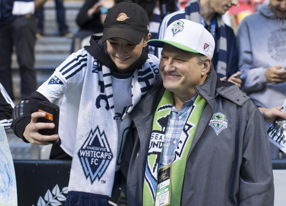 Seattle Sounders co-owner Drew Carey (R) poses for a photo with a Vancouver Whitecaps fan before an MLS playoff game on Oct. 29, 2017. (AP)