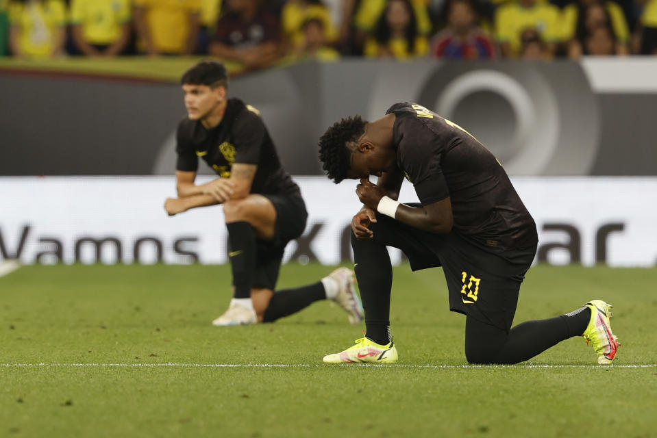 Brazil's Vinicius Junior kneels before an international friendly soccer match between Brazil and Guinea at the RCDE Stadium in Barcelona, Spain, Saturday, June 17, 2023. (AP Photo/Joan Monfort)