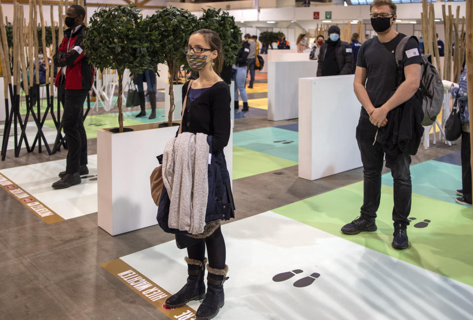 Police officers and wait in a line to receive their COVID-19 vaccine at the Brussels Expo center in Brussels, Thursday, March 4, 2021. The Expo is one of the largest vaccination centers in Belgium. (AP Photo/Olivier Matthys)