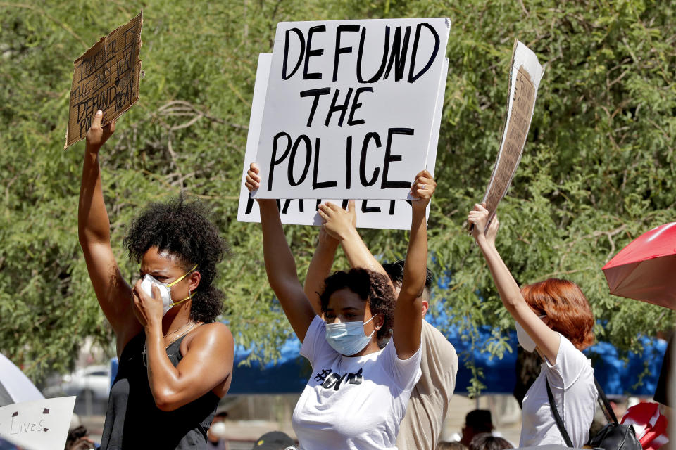 FILE - In this June 3, 2020, file photo, protesters rally in Phoenix, demanding the Phoenix City Council defund the Phoenix Police Department, following the death of George Floyd. Some Republican-controlled states have responded to persistent calls for police reform by moving in the other direction. An Associated Press review of legislation found that states where lawmakers pushed back against the police-reform movement included Arizona, Florida, Iowa, Oklahoma, Tennessee and Wyoming. (AP Photo/Matt York, File)