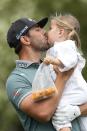 Erik van Rooyen, of South Africa, gets a kiss from his daughter Valerie on the third hole during the par-3 contest at the Masters golf tournament at Augusta National Golf Club Wednesday, April 10, 2024, in Augusta, GA. (AP Photo/George Walker IV)