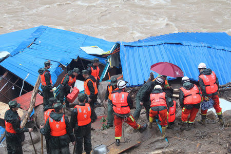 Paramilitary policemen search for missing people at the site of a landslide in Sanming, Fujian province, China, May 8, 2016. China Daily/via REUTERS
