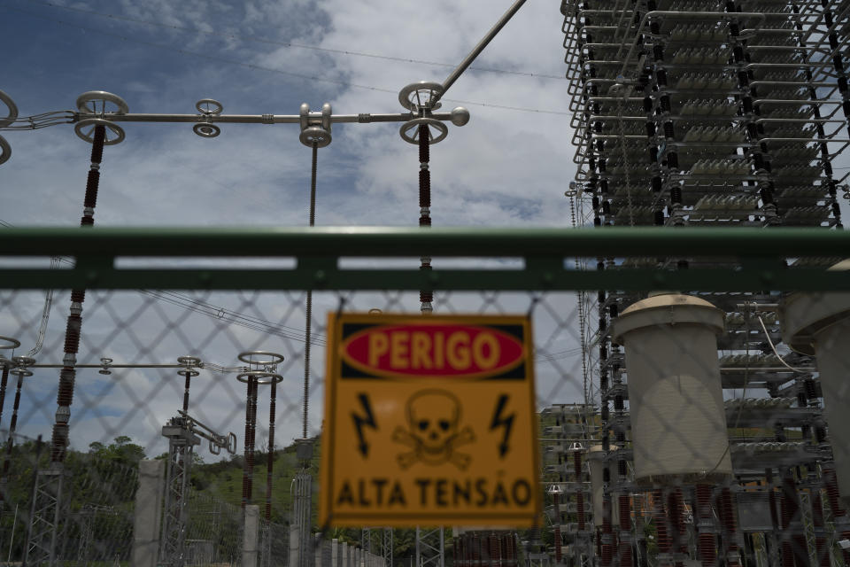 En esta imagen del 4 de diciembre de 2019, un cartel de advertencia sobre el alto voltaje, colocado ante la subestación eléctrica Transmisor de Energía de Río Xingu en Paracambi, Brasil, que transmite la energía eléctrica generada en la presa de Belo Monte. (AP Foto/Leo Correa)