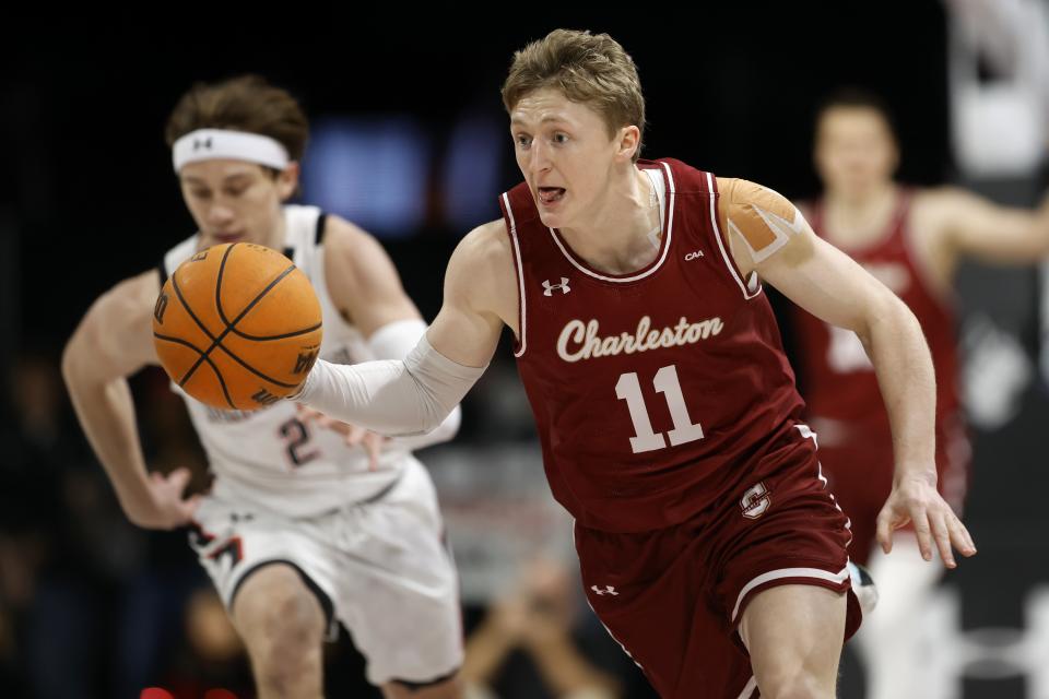 Charleston's Ryan Larson (11) drives for the basket upcourt ahead of Northeastern's Glen McClintock (2) during the first half of an NCAA college basketball game, Saturday, Jan. 21, 2023, in Boston. (AP Photo/Michael Dwyer)