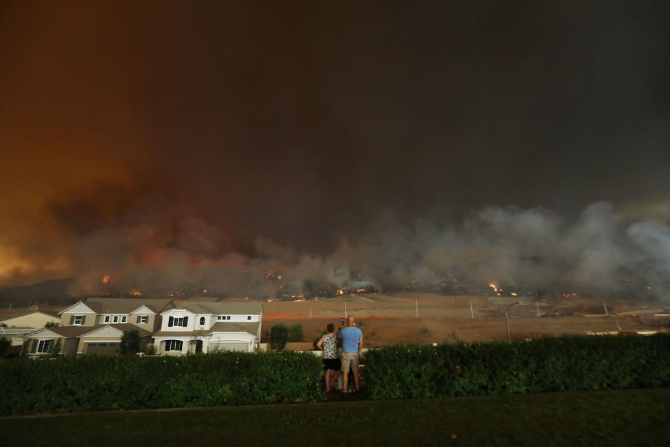 <p>People watch as the Holy Fire burns in Cleveland National Forest near homes on Aug. 9, 2018 in Corona, Calif. (Photo: Mario Tama/Getty Images) </p>