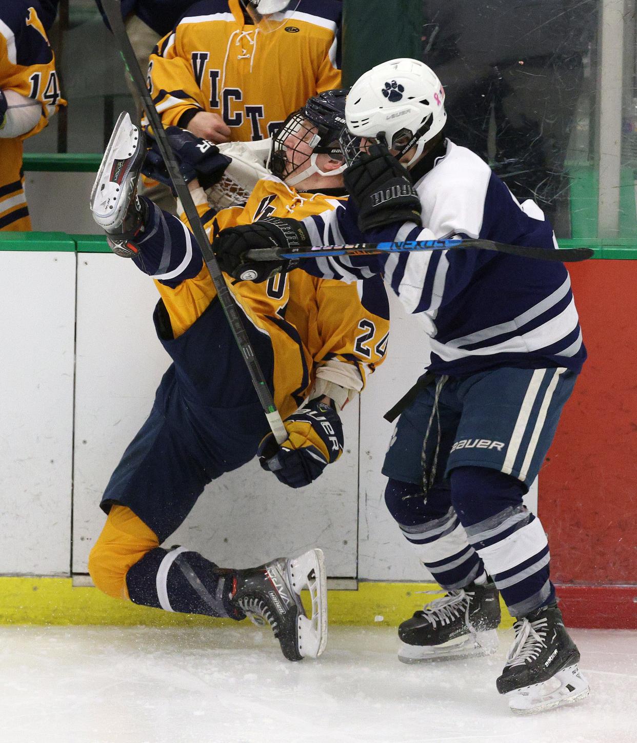 Victor’s Aiden Cox-Bagley is checked by Pittsford’s Logan Wood. 