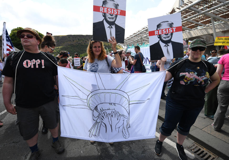 <p>People hold anti-Trump signs during a demonstration in Edinburgh, Scotland, on July 14, 2018, while the U.S. president visits Trump Turnberry Luxury Collection Resort in western Scotland. (Photo: Jeff J. Mitchell/Getty Images) </p>