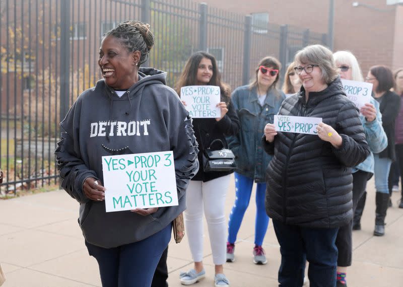 FILE PHOTO: Abortion rights activist Fabian Hill holds a sign while waiting in line to see former U.S. President Barack Obama and Michigan Governor Gretchen Whitmer before mid-term elections in Detroit