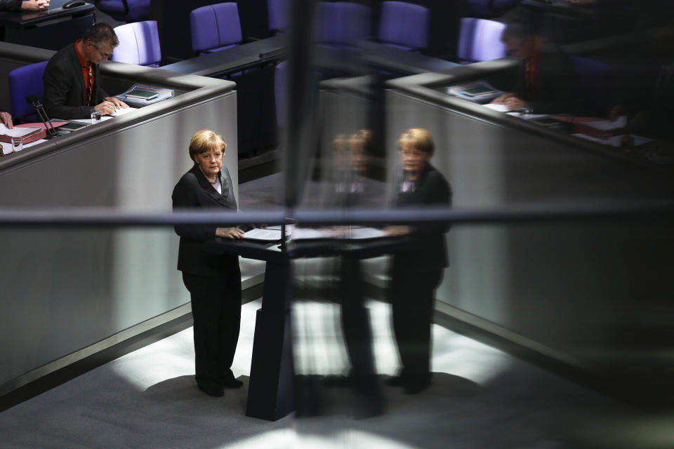 German Chancellor Angela Merkel delivers her speech, on the Ukrainian crisis at the parliament Bundestag in Berlin, Thursday, March 13, 2014. Reflections caused by glass pains of the visitors' tribune. German Chancellor Angela Merkel warned Moscow on Thursday that if it continues its current course in the Ukraine crisis, Russia risks “massive” political and economic consequences. In an address to Parliament, Merkel told lawmakers the only way out of the crisis is through diplomacy and assured lawmakers that “the use of the military is no option.” (AP Photo/Markus Schreiber)