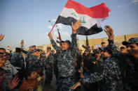 <p>JUL. 2, 2017 – Members of the Iraqi federal police dance with children and a national flag during a celebration in the Old City of Mosul, where the gruelling battle to retake Iraq’s second city from Islamic State (IS) group fighters is now nearing its end, on July 2, 2017. (Photo: Ahmad al-Rubaye/AFP/Getty Images) </p>