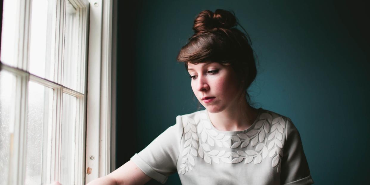 sad woman sitting by window