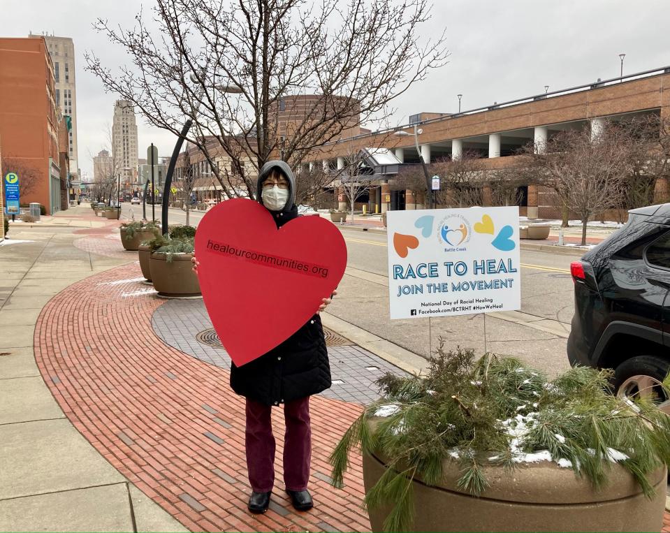 Kathy Antaya, a member of the Battle Creek Coalition for Truth, Racial Healing and Transformation, distributes hearts and signs in downtown Battle Creek on Jan. 19, 2021.