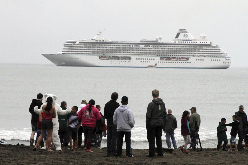 FILE - People prepare to take a polar plunge in the Bering Sea in front of the luxury cruise ship Crystal Serenity, which anchored just outside Nome, Alaska, because it was too big to dock at the Port of Nome, Aug. 21, 2016. Shipping lanes that were once clogged with ice for much of the year along Alaska's western and northern coasts have relented thanks to global warming, and the nation's first deep water Arctic port should be operational in Nome by the end of the decade. (AP Photo/Mark Thiessen, File)