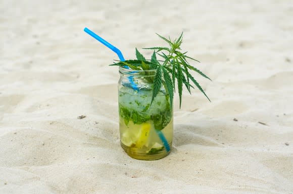 A beverage on the beach with a marijuana leaf in it