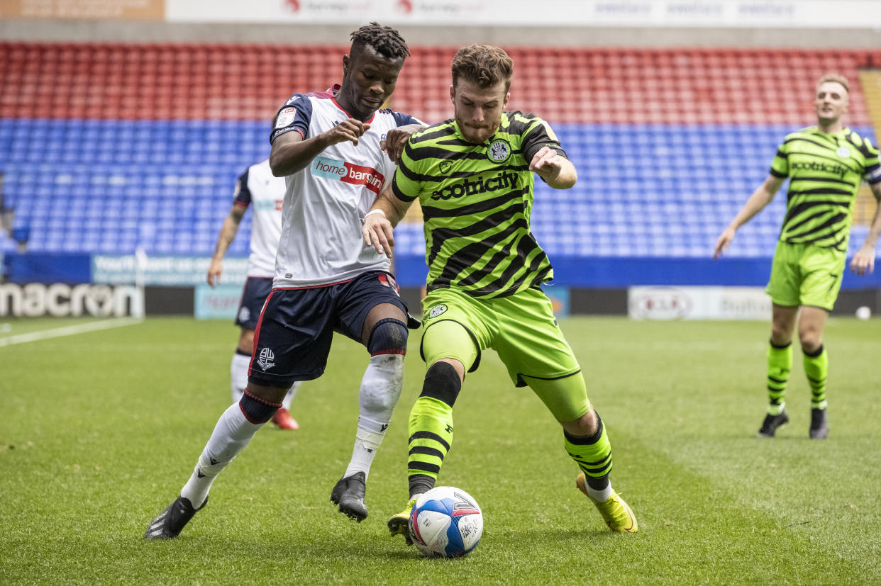 Jugadores del Forest Green Rovers y del Bolton Wanderers luchando por el balón durante un partido