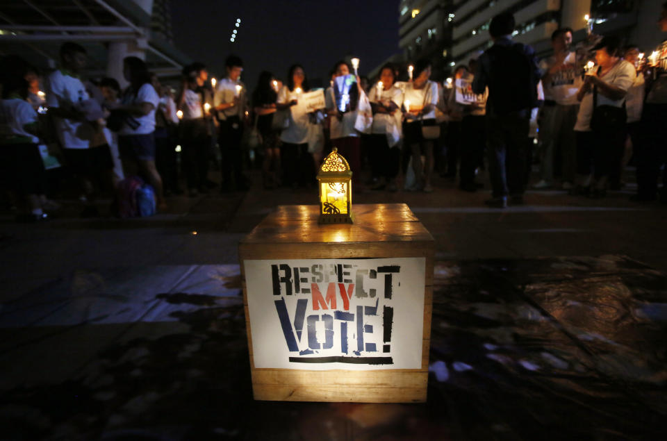 Members of Thailand's "White Shirt" movement attend a candlelight vigil to demand democratic elections and political reforms in Bangkok, Thailand, Friday, Jan. 31, 2014. Thailand's general election is scheduled for Sunday, Feb. 2, 2014, but the main opposition Democrat Party is boycotting it, and its supporters seeking to scuttle it by blocking access to polling stations throughout Bangkok. The "White Shirt" movement is intended to give voice to Thais who are neither anti-government protesters nor pro-government "Red Shirt" activists. (AP Photo/Wally Santana)