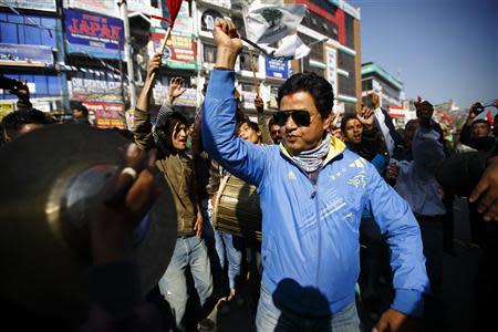 Supporters of the Nepali Congress Party cheer for their party as Constituent Assembly Election scores are displayed on a screen outside the Constitution Assembly Building in Kathmandu November 21, 2013. REUTERS/Navesh Chitrakar