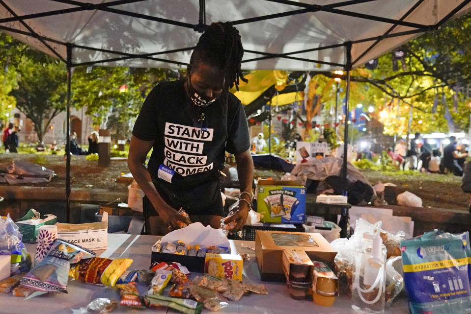 Rose Henderson helps out at a booth in Jefferson Square Park, Thursday, Sept. 24, 2020, in Louisville, Ky. A grand jury has indicted one officer on criminal charges six months after Breonna Taylor was fatally shot by police in Kentucky. The jury presented its decision against fired officer Brett Hankison Wednesday to a judge in Louisville, where the shooting took place. (AP Photo/Darron Cummings)