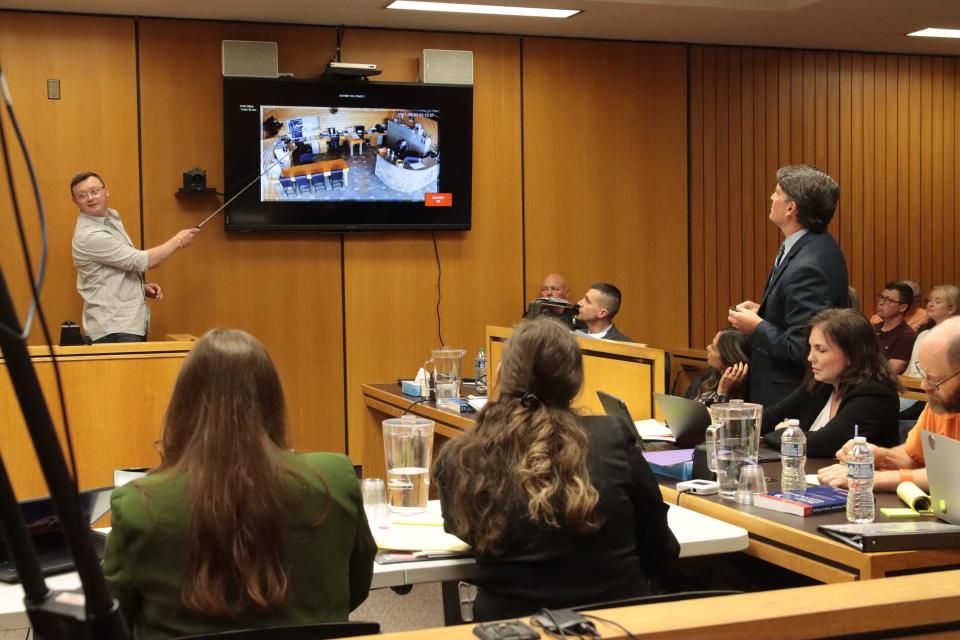 Zack Bock, left, son of Dee Warner and a former accountant for the Warner family businesses, testifies Thursday, May 2, 2024, in Lenawee County District Court about the layout of the business office during the preliminary examination of murder and evidence tampering charges against Dale Warner in the disappearance of his wife, Dee. Standing at right is Lenawee County Assistant Prosecutor Dave McCreedy.