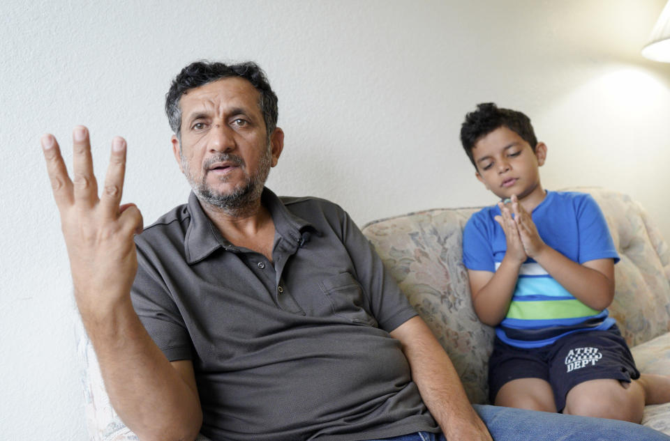 In this Sept. 29, 2018 photo, Hadi Mohammed gestures as he sits with his 9 year old son Mohammed Ghaleb, in their Lincoln, Neb. apartment. Death threats drove Hadi Mohammed out of Iraq and to a small apartment in Nebraska, where he and his two young sons managed to settle as refugees. But the danger hasn’t been enough to allow his wife to join them. (AP Photo/Nati Harnik)