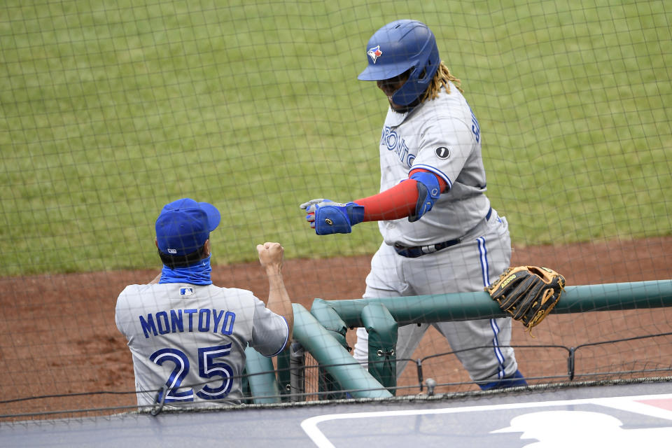 Toronto Blue Jays' Vladimir Guerrero Jr., right, celebrates his home run with manager Charlie Montoyo (25) during the second inning of a baseball game against the Washington Nationals, Tuesday, July 28, 2020, in Washington. (AP Photo/Nick Wass)