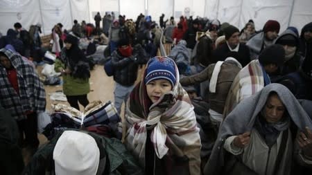 A child looks on as migrants wait in line inside a registration camp in Presevo, Serbia, January 20, 2016. REUTERS/Marko Djurica