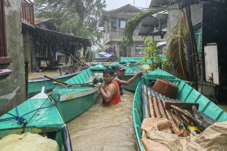 Residents bring their boats to prevent them from being swept away by a swollen river due to Typhoon Doksuri in Laoag city, Ilocos Norte province, northern Philippines, Wednesday, July 26, 2023. Typhoon Doksuri blew ashore in a cluster of islands and lashed northern Philippine provinces with ferocious wind and rain Wednesday, leaving at least a few people dead and displacing thousands of others as it blew roofs off rural houses, flooded low-lying villages and toppled trees, officials said. (AP Photo/Bernie Sipin Dela Cruz)